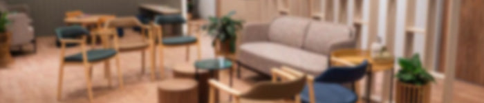 Blurred image of a WSD interior with tables, chairs, and a sofa.