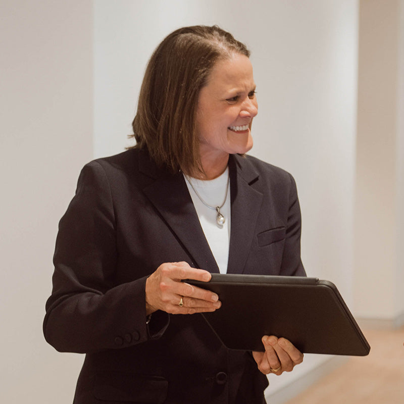 Dr Nerida McDonald holding a tablet with a neutral background