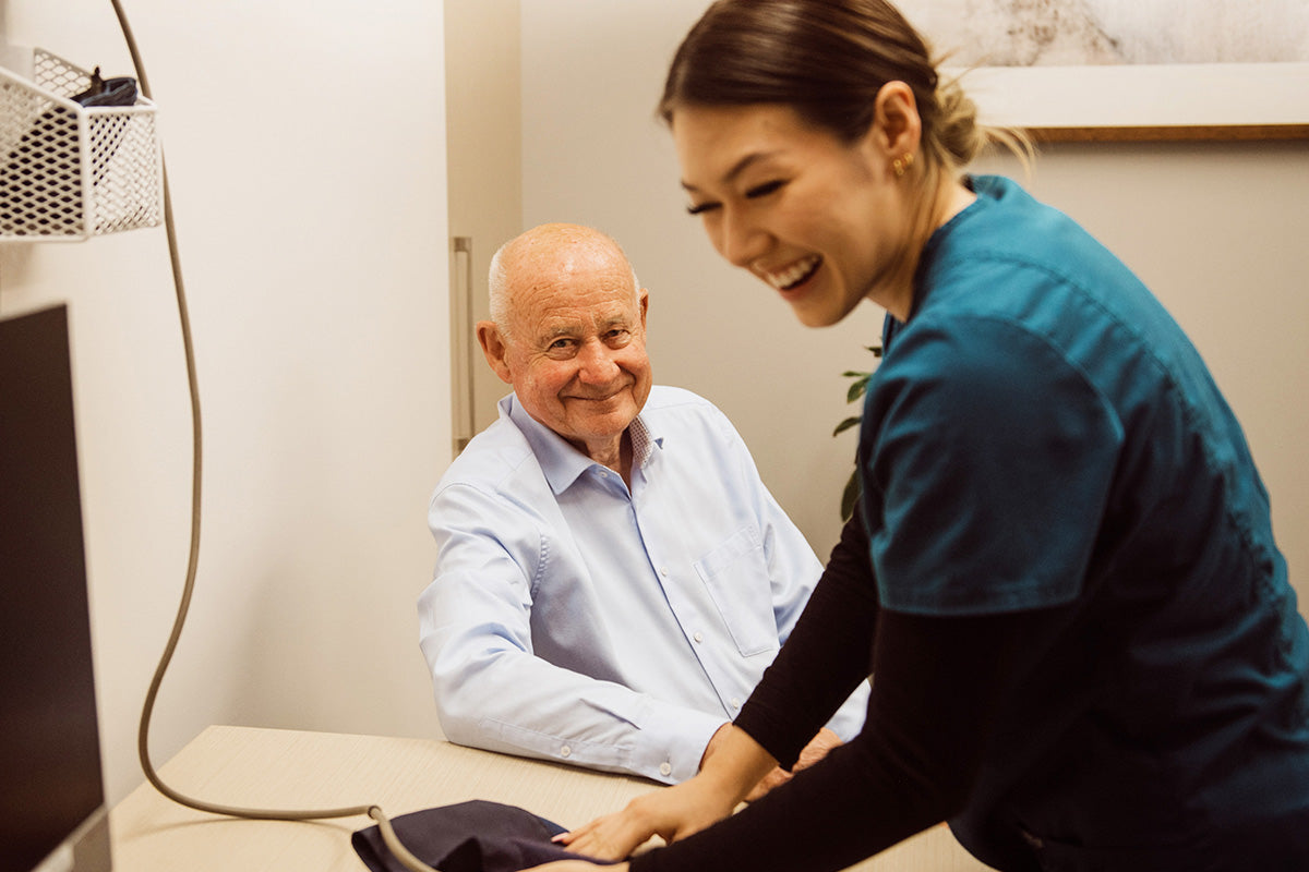 Nurse Lyca assisting a male patient with a computer in an office setting