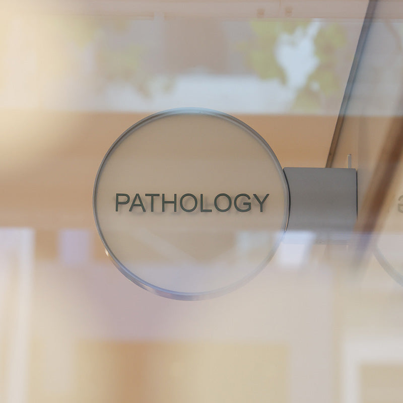 Magnifying glass with 'PATHOLOGY' text over a blurred background