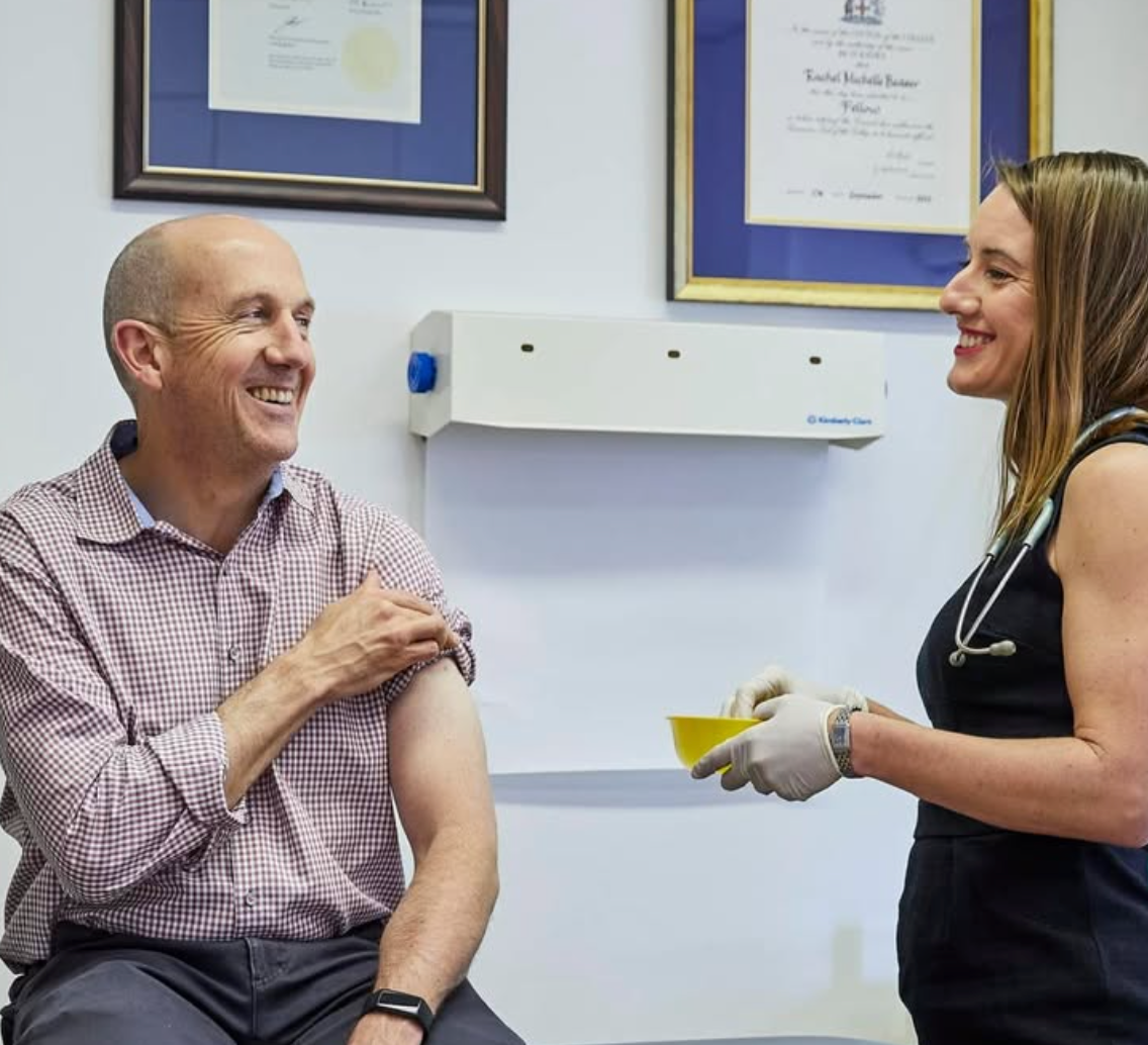 Person receiving a vaccination from a healthcare professional in a medical setting.
